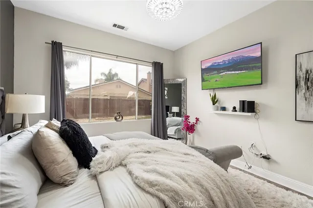 a bedroom with a bed and a flat screen tv