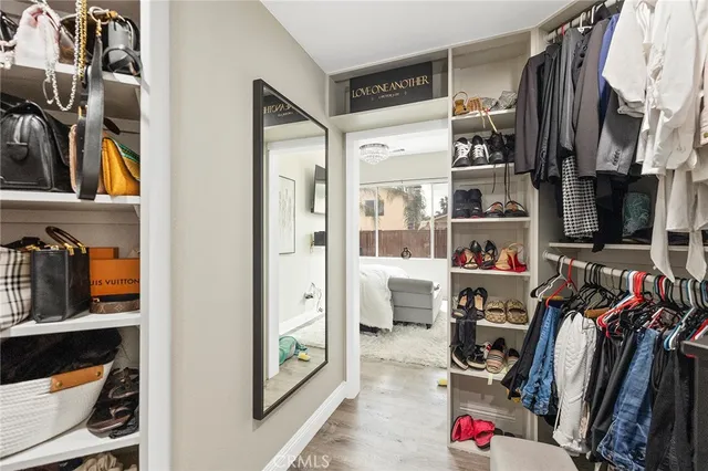 a view of walk in closet with clothes and shoes