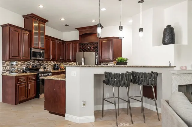 a kitchen with stainless steel appliances kitchen island granite countertop a stove a sink and a refrigerator