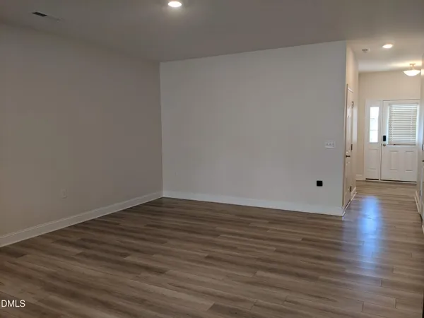 a view of an empty room and wooden floor
