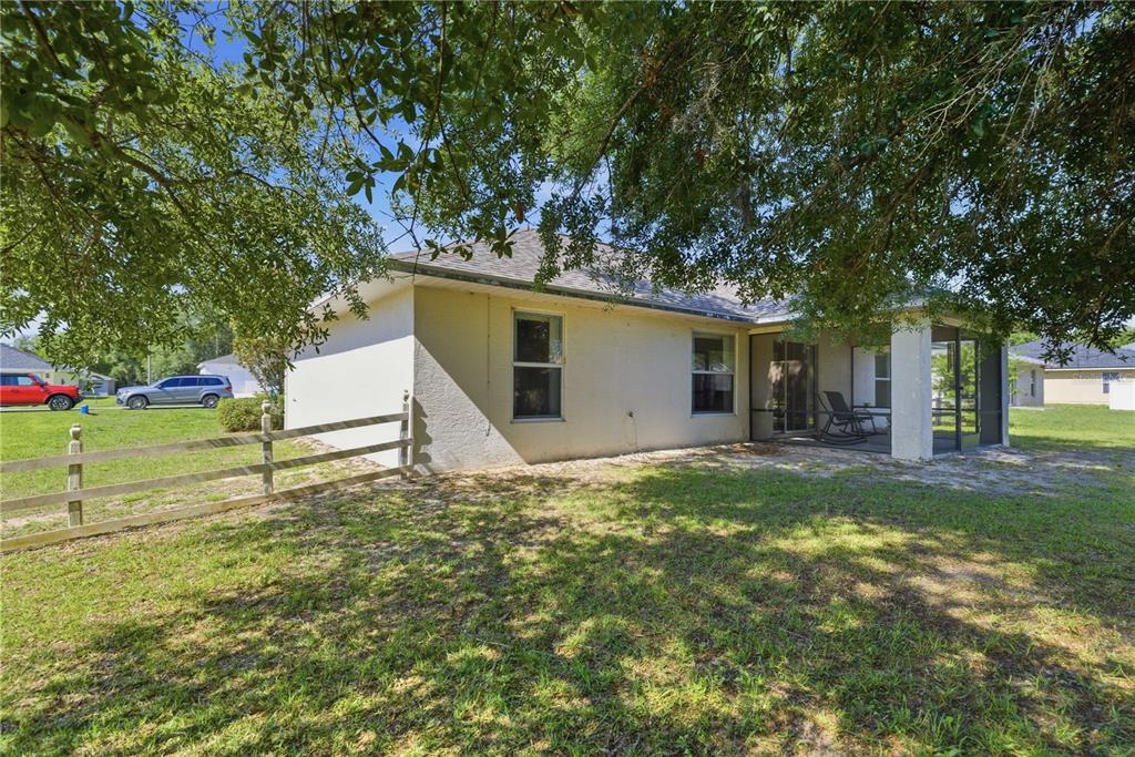 3959 Southwest 129th Street Ocala, FL 34473 - Photo 23 of 27 a white house that has a tree in front of it