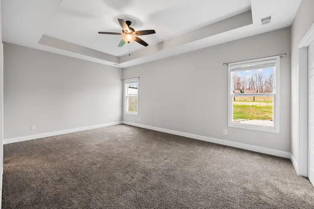 an empty room with a window and a ceiling fan