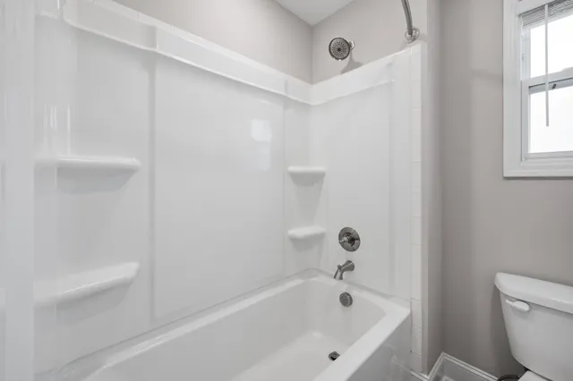 a white bath tub sitting next to a white toilet