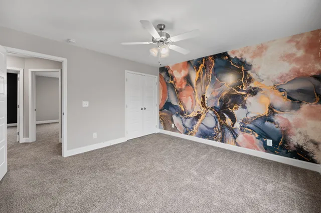 an empty room with ceiling fan and window