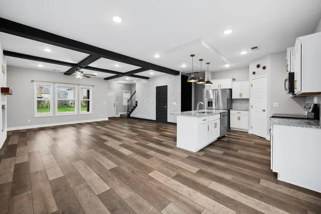 a view of a kitchen with wooden floor and electronic appliances