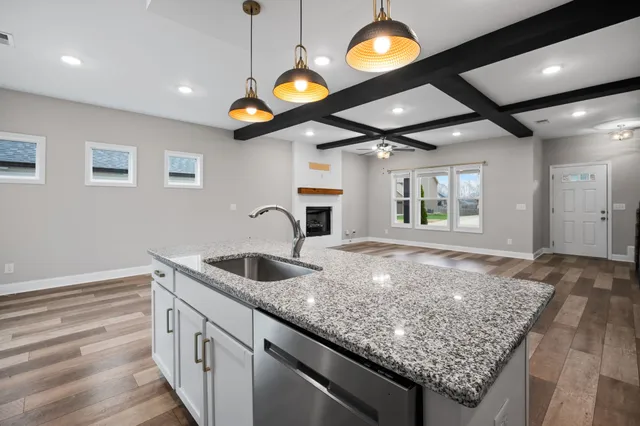 a kitchen with stainless steel appliances granite countertop a sink a oven and a large window