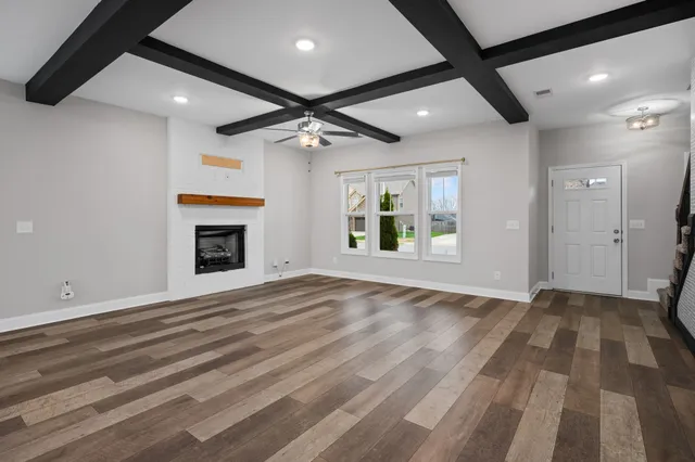 a view of an empty room with window and fire place