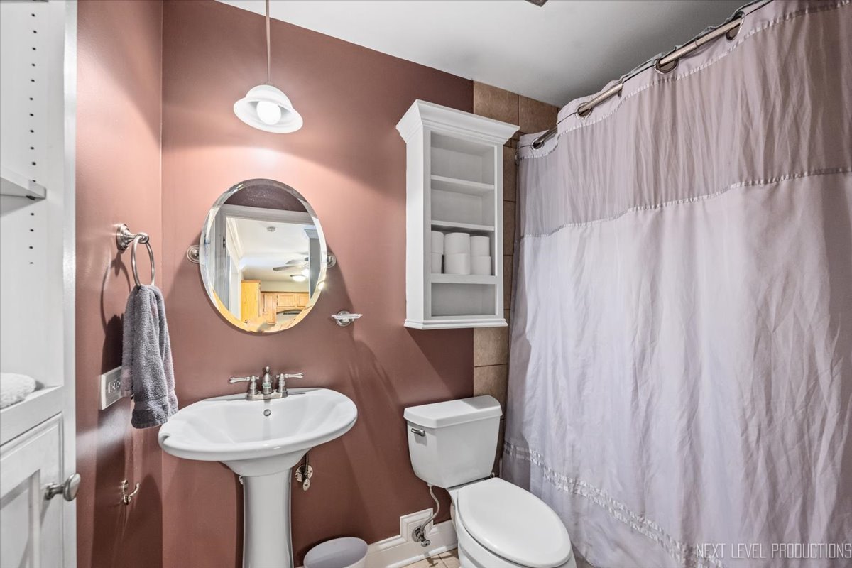 2100 Light Road, Unit 109 Oswego, IL 60543 - Photo 15 of 17 a bathroom with a toilet sink and mirror