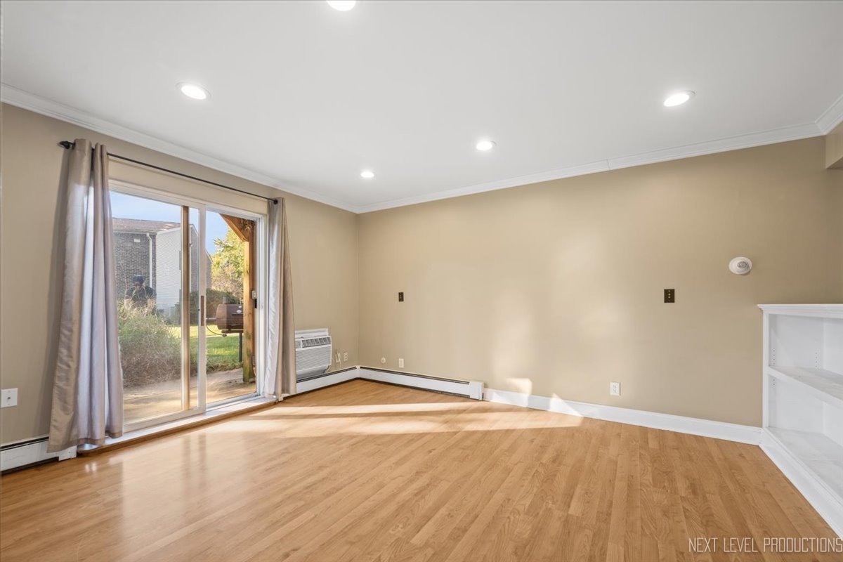 2100 Light Road, Unit 109 Oswego, IL 60543 - Photo 3 of 17 an empty room with wooden floor and windows