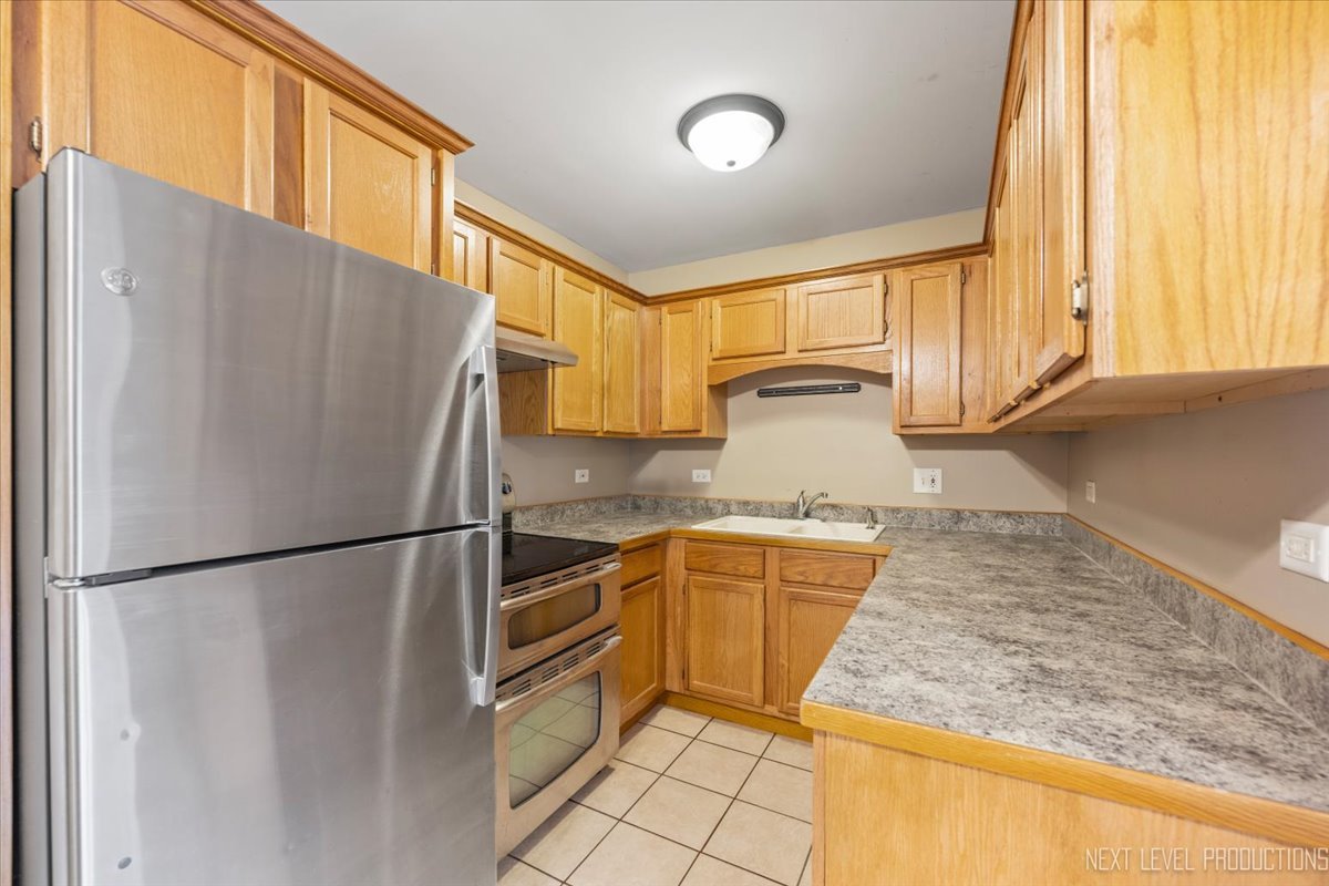 2100 Light Road, Unit 109 Oswego, IL 60543 - Photo 10 of 17 a kitchen with stainless steel appliances granite countertop a refrigerator a sink and a stove