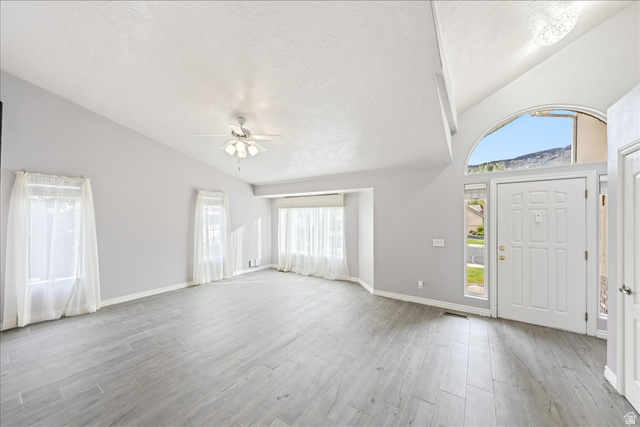 7 Reflection Way St. George, UT 84770 - Photo 6 of 54 Entryway featuring healthy amount of natural light, light wood-style floors, a textured ceiling, high vaulted ceiling, and ceiling fan