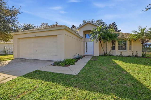a view of a house with a backyard and a tree