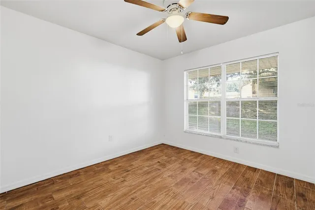 an empty room with a window and a fan