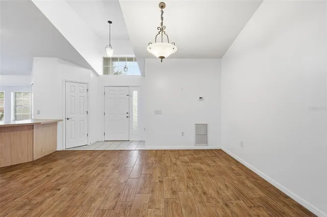 a view of empty room with wooden floor and ceiling fan