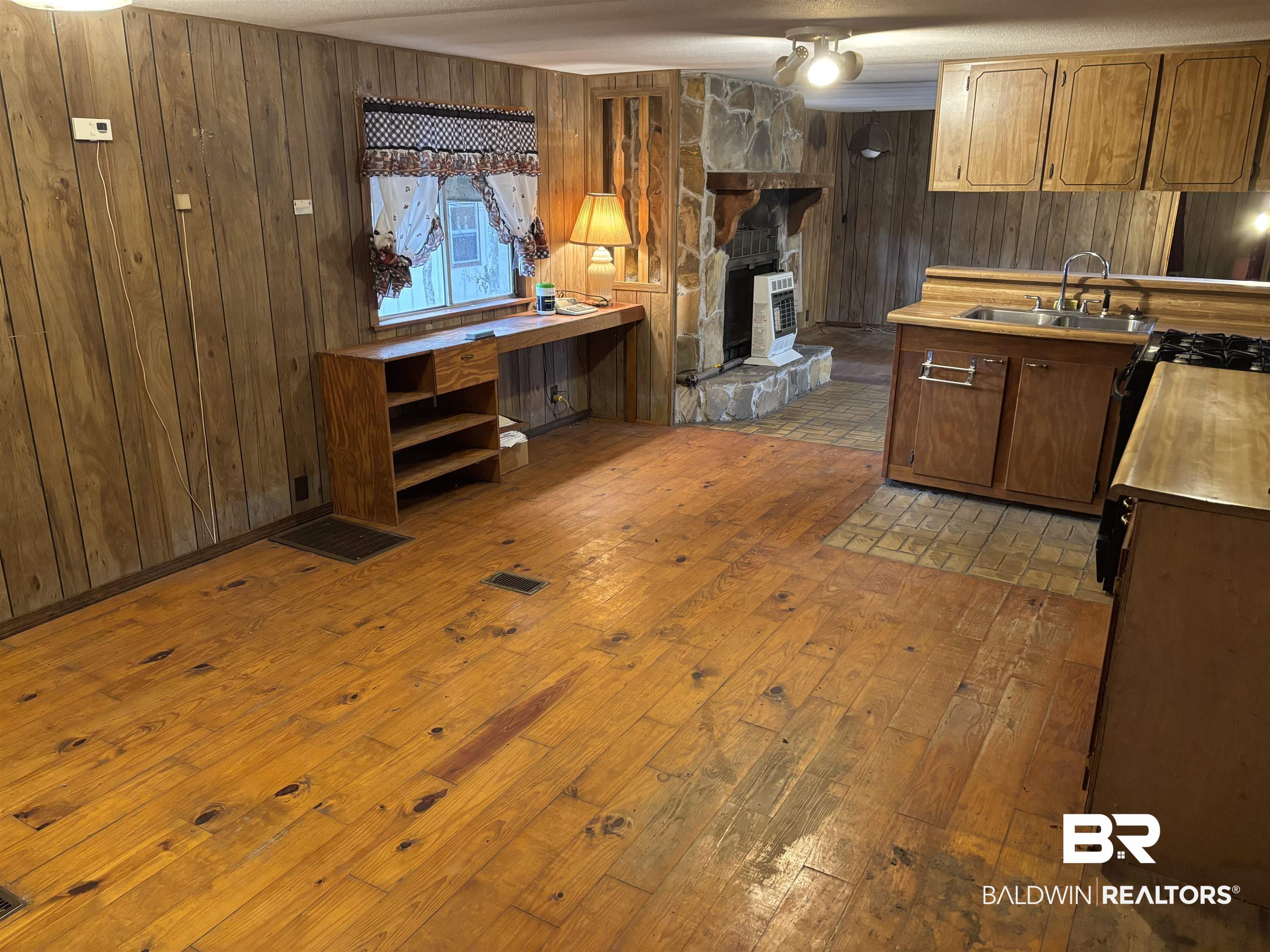 15575 Rogers Drive Chunchula, AL 36521 - Photo 25 of 42 Kitchen with wooden walls, dark wood finished floors, light countertops, a fireplace, and a sink