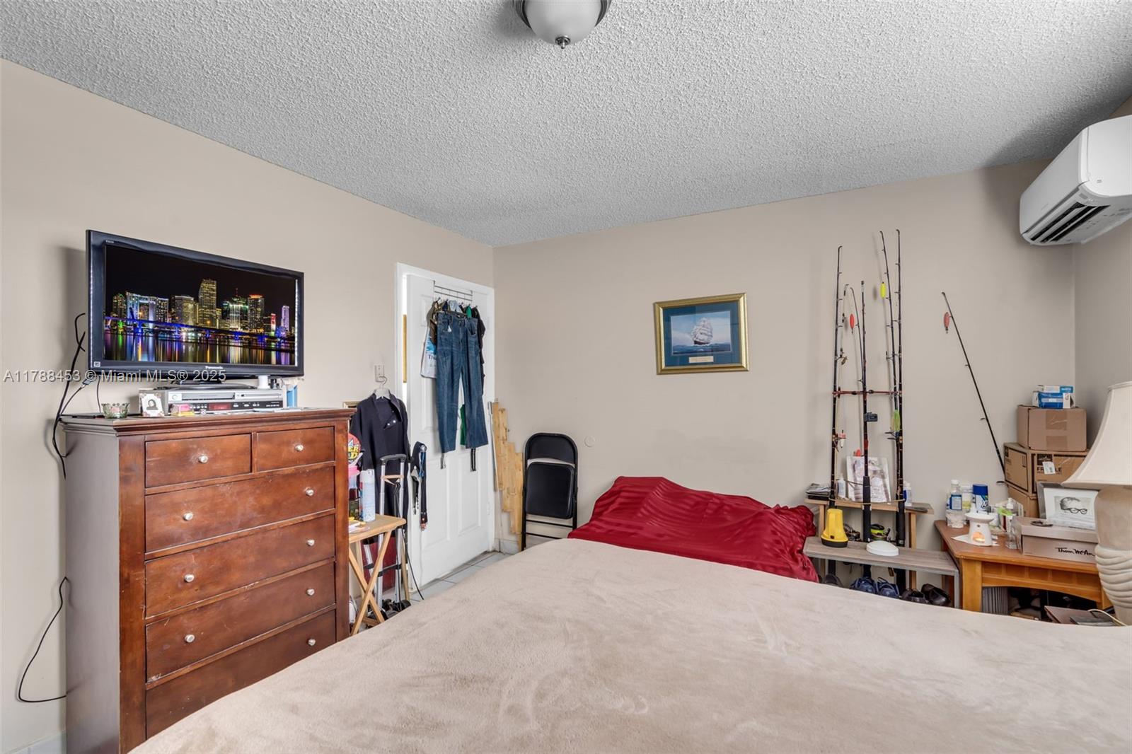 35 Southwest 60th Avenue Miami, FL 33144 - Photo 21 of 27 a bedroom with a bed and a flat tv screen on dresser