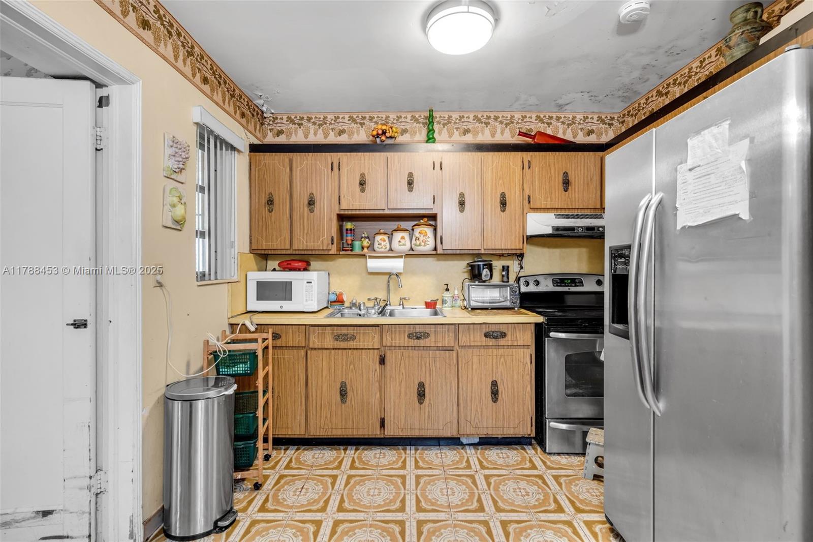 35 Southwest 60th Avenue Miami, FL 33144 - Photo 8 of 27 a kitchen with stainless steel appliances a refrigerator sink and cabinets