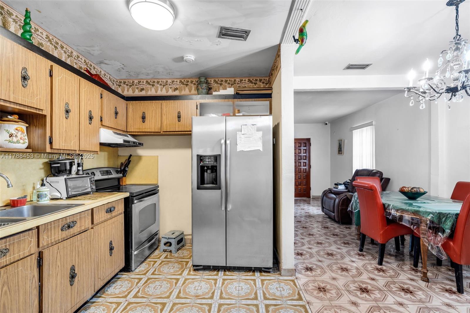 35 Southwest 60th Avenue Miami, FL 33144 - Photo 9 of 27 a kitchen with stainless steel appliances granite countertop a refrigerator a sink dishwasher a dining table and chairs with wooden floor