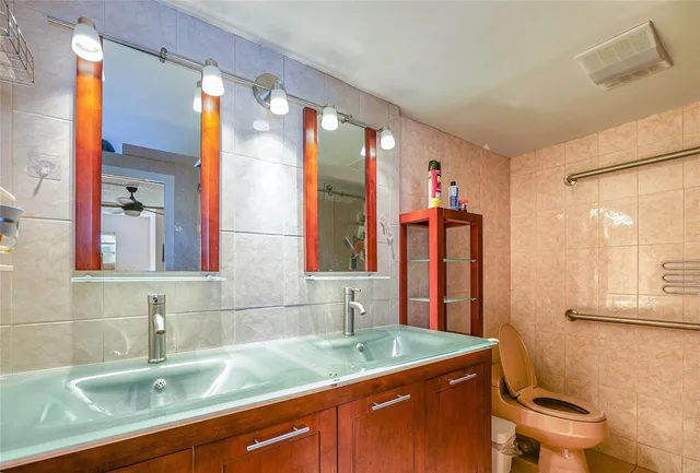 a bathroom with a granite countertop sink mirror vanity and toilet