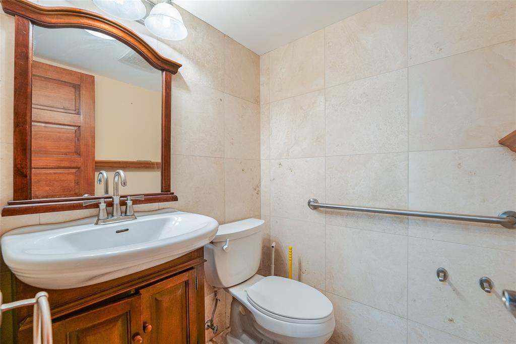 3940 Inverrary Boulevard, Unit 108A Lauderhill, FL 33319 - Photo 18 of 39 a bathroom with a sink a toilet and a mirror