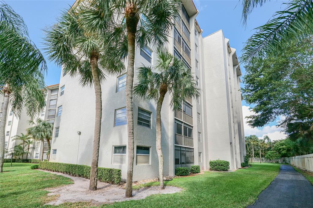 3940 Inverrary Boulevard, Unit 108A Lauderhill, FL 33319 - Photo 38 of 39 front view of house with a yard and palm trees