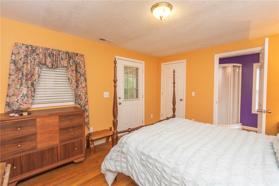 1116 Leatherdale Road Iva, SC 29655 - Photo 19 of 46 This inviting bedroom features hardwood flooring and direct outdoor access, offering comfort and convenience.