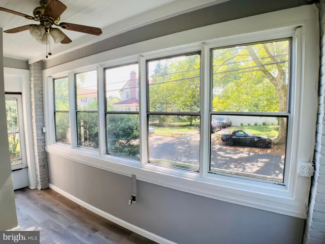 a view of a room that has a window and a ceiling fan