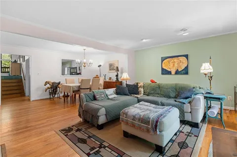 a living room with furniture and a flat screen tv with wooden floor