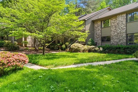 a view of staircase with white walls and a painting on the wall