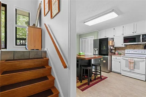 a kitchen with stainless steel appliances a stove a refrigerator and a dining table