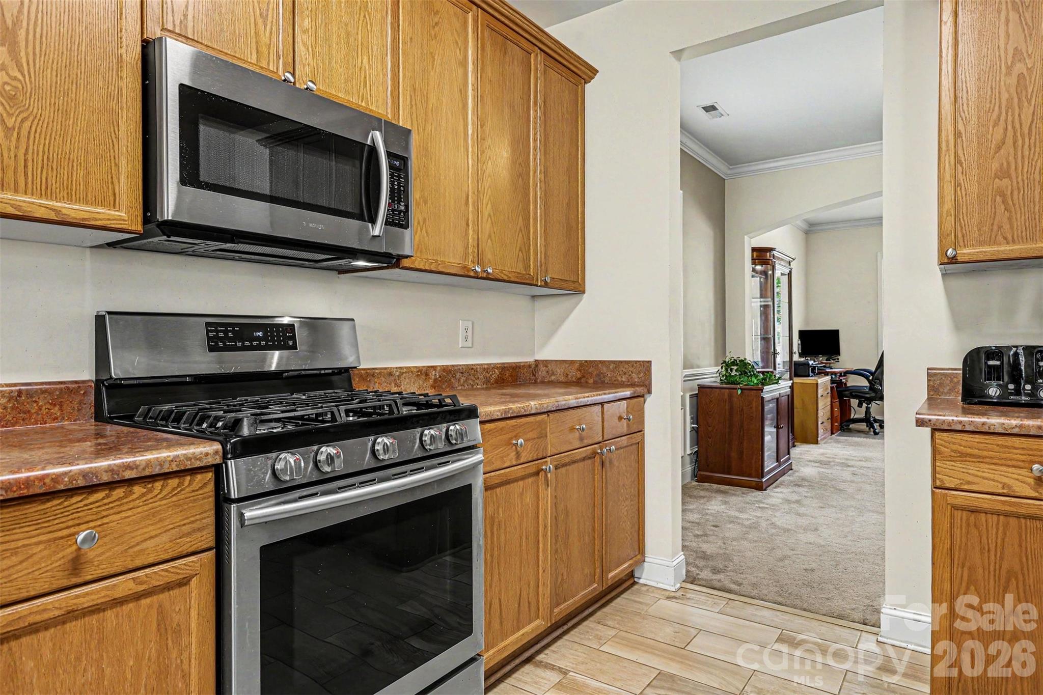 3035 Proverbs Court Monroe, NC 28110 - Photo 7 of 30 a kitchen with stainless steel appliances granite countertop a stove microwave and cabinets