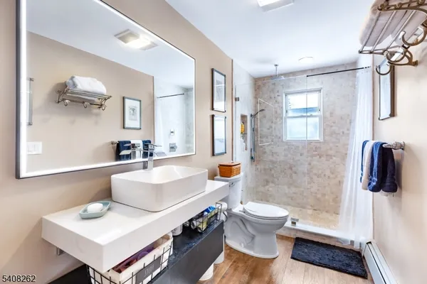 a bathroom with a sink a toilet and shower