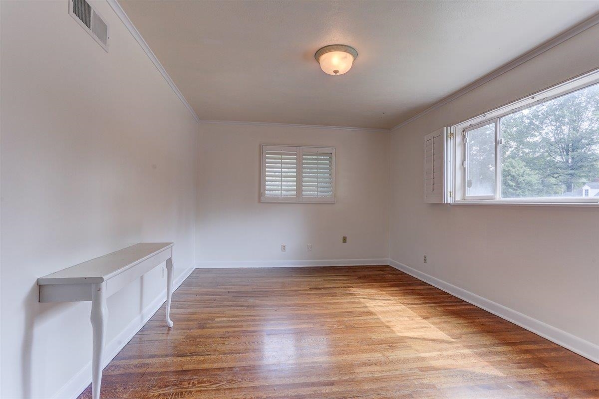 5680 North Angela Road Memphis, TN 38120 - Photo 13 of 33 Spare room featuring healthy amount of natural light, crown molding, and light wood-style flooring