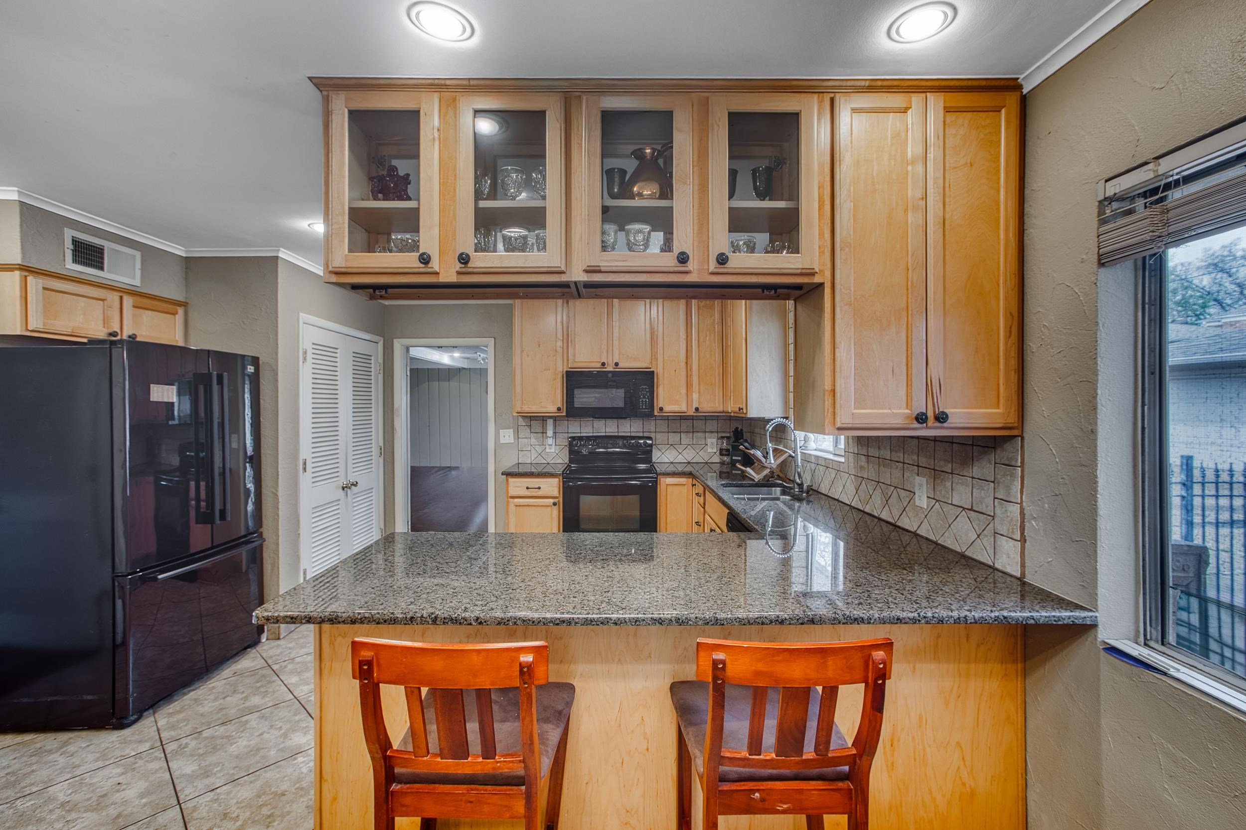 5680 North Angela Road Memphis, TN 38120 - Photo 17 of 33 Kitchen featuring visible vents, black appliances, a sink, a peninsula, and light tile patterned floors
