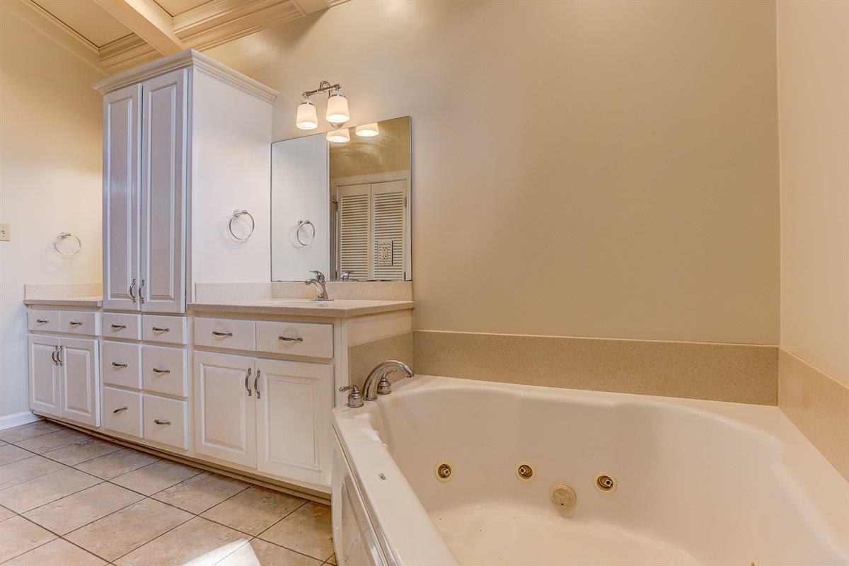 5680 North Angela Road Memphis, TN 38120 - Photo 23 of 33 Full bath featuring double vanity, light tile patterned flooring, and a jetted tub