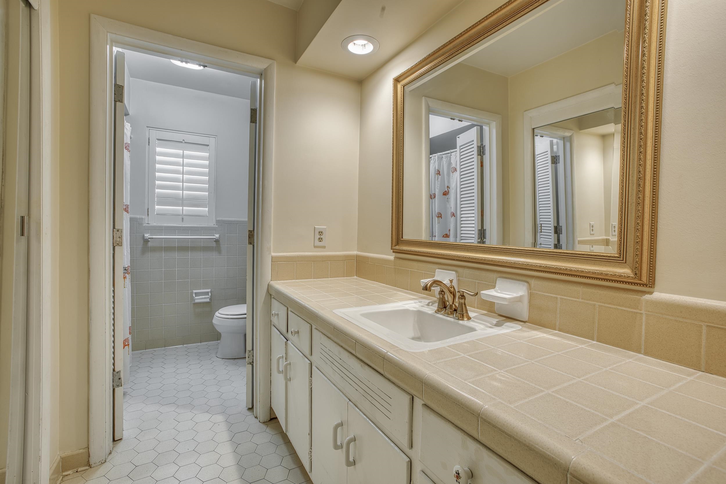 5680 North Angela Road Memphis, TN 38120 - Photo 25 of 33 Full bathroom with vanity, wainscoting, tile walls, toilet, and tile patterned floors