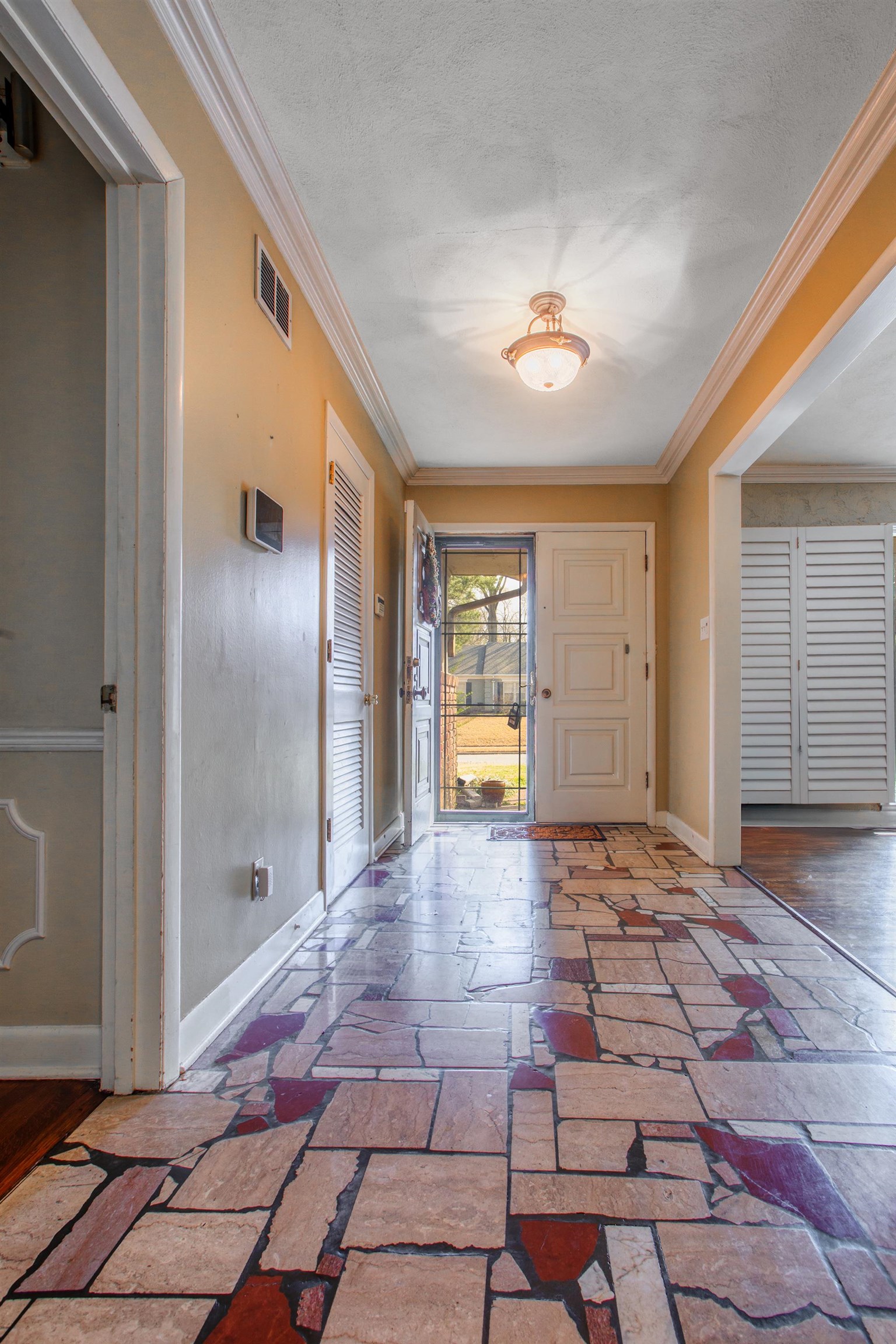 5680 North Angela Road Memphis, TN 38120 - Photo 26 of 33 Entrance foyer with stone tile floors, ornamental molding, and a textured ceiling