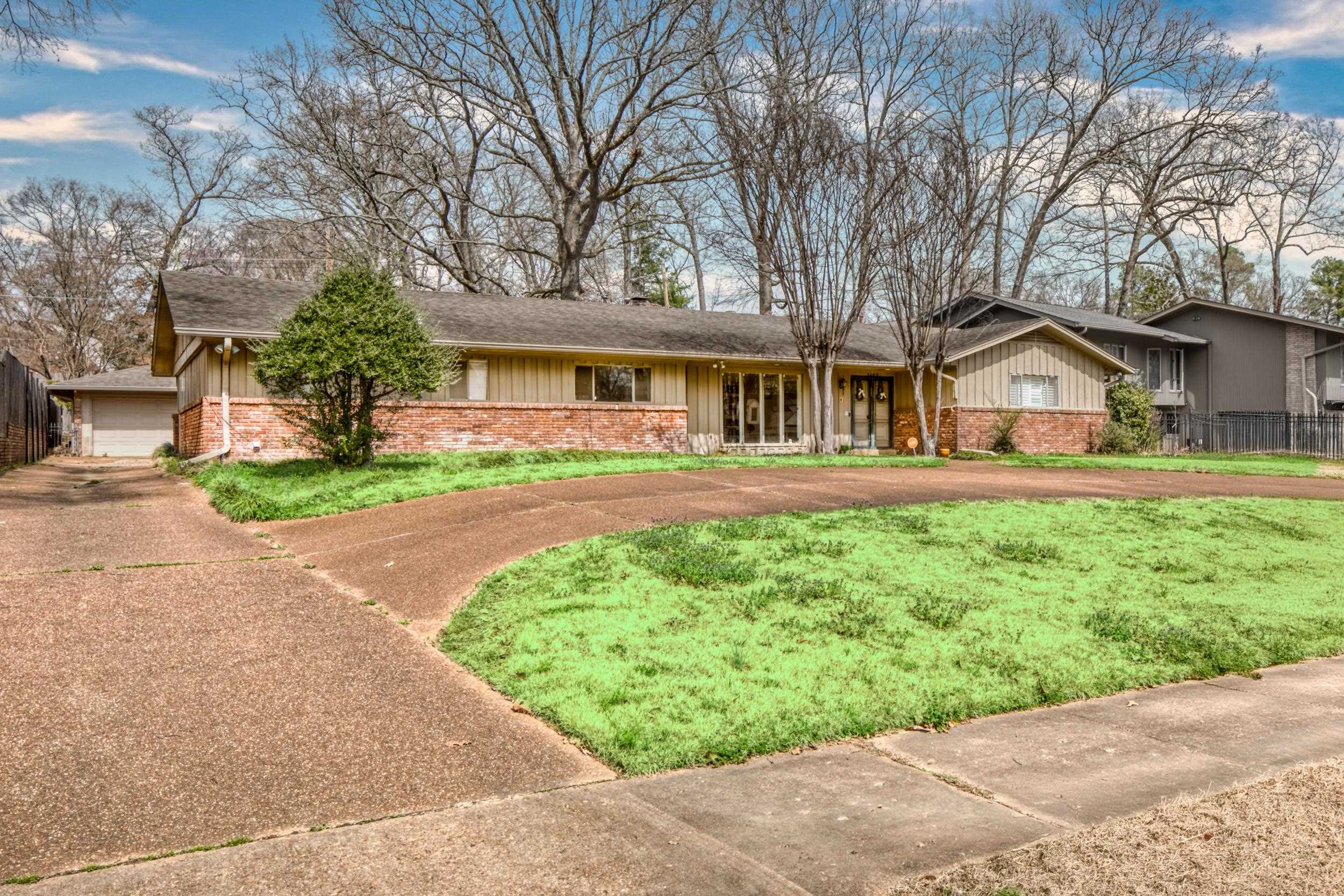 5680 North Angela Road Memphis, TN 38120 - Photo 30 of 33 Ranch-style house featuring board and batten siding, concrete driveway, a garage, and a shingled roof
