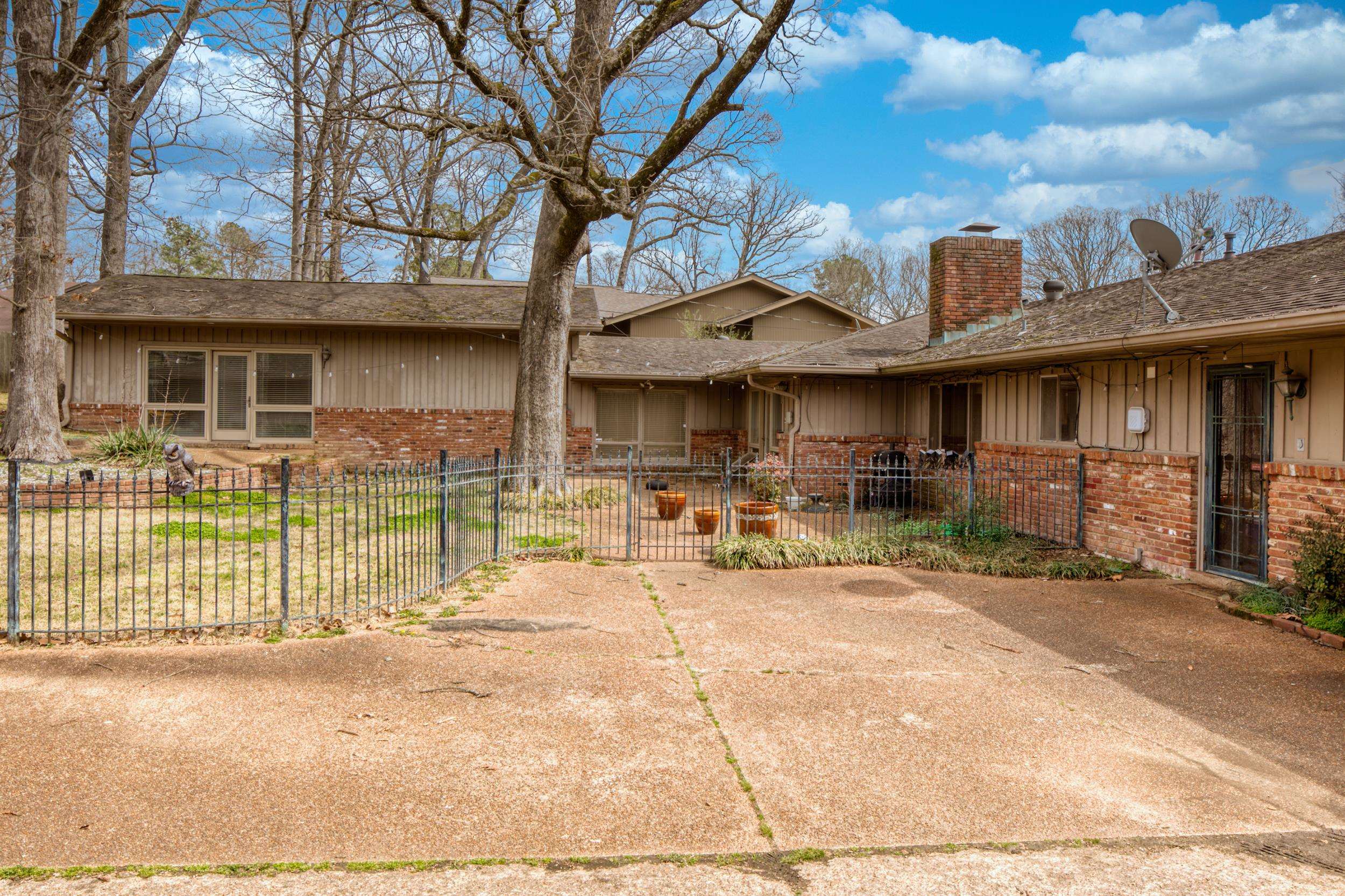 5680 North Angela Road Memphis, TN 38120 - Photo 32 of 33 Back of property featuring fence, roof with shingles, brick siding, a chimney, and board and batten siding