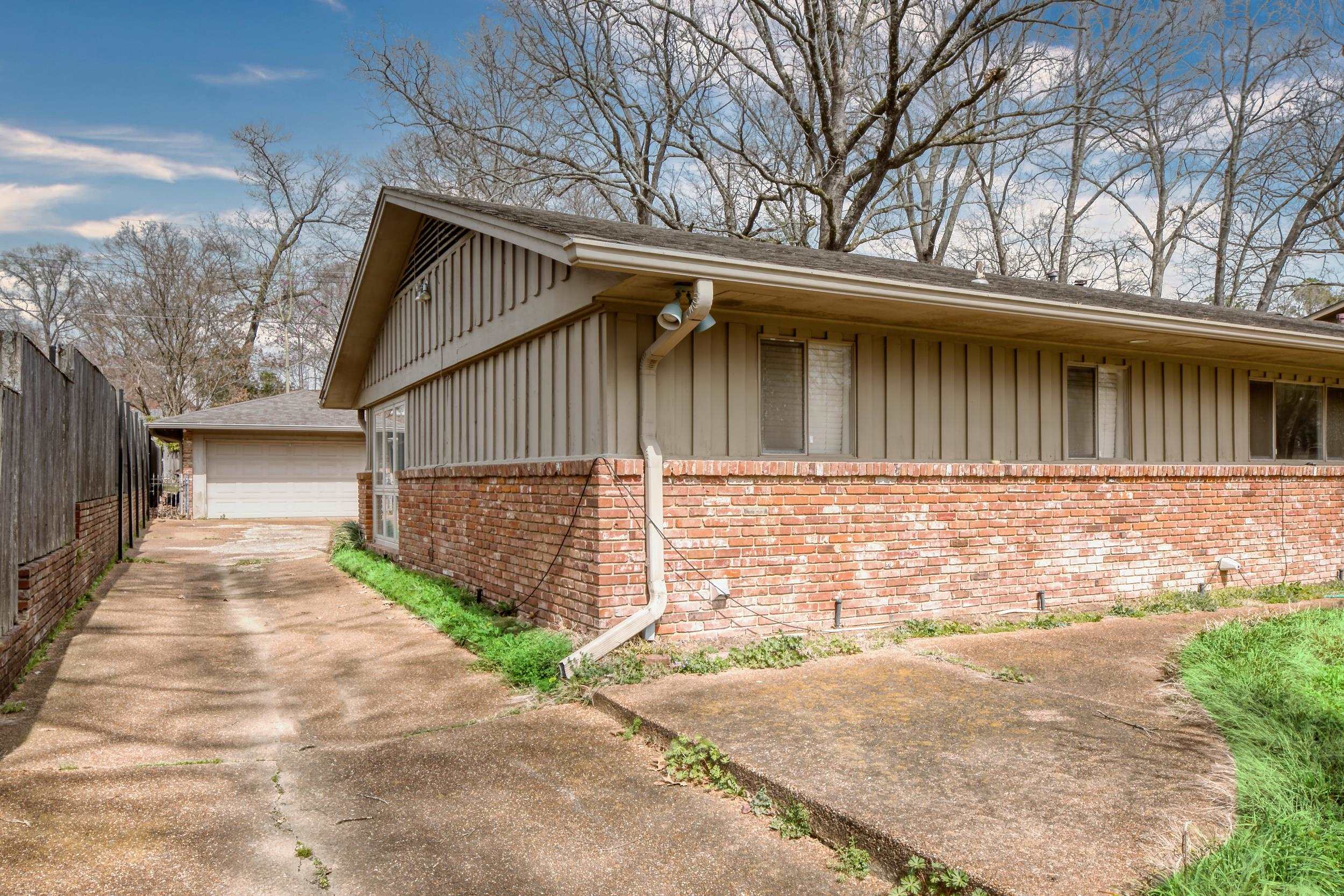5680 North Angela Road Memphis, TN 38120 - Photo 33 of 33 View of home's exterior featuring an outbuilding, board and batten siding, brick siding, and fence
