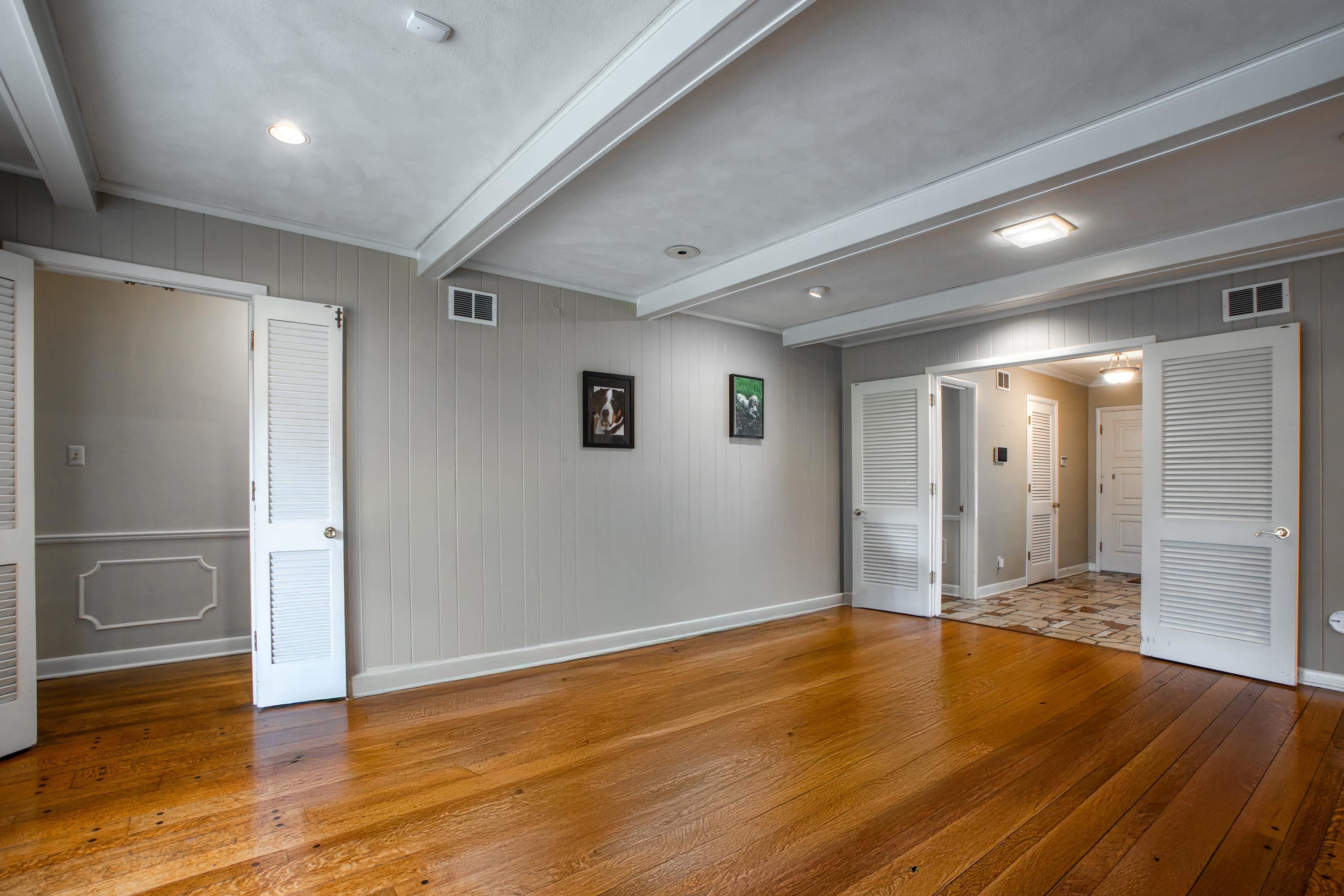 5680 North Angela Road Memphis, TN 38120 - Photo 6 of 33 Unfurnished bedroom featuring wood-type flooring, wooden walls, and beam ceiling