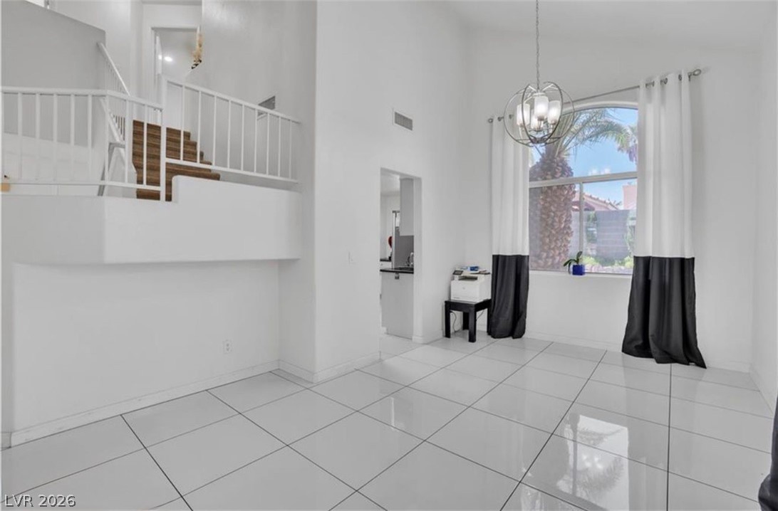 6429 Winding Ridge Las Vegas, NV 89156 - Photo 13 of 22 A spacious, naturally illuminated room features high ceilings and modern tile flooring.