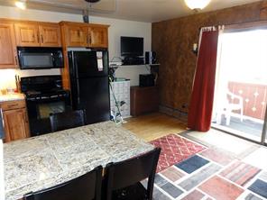 180 Evergreen Road, Unit 202E Dillon, CO 80435 - Photo 5 of 24 a kitchen with stainless steel appliances kitchen island granite countertop a refrigerator and microwave