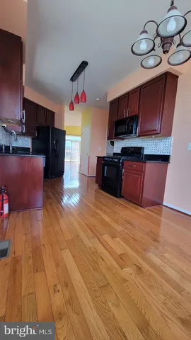 a kitchen with stainless steel appliances wooden floors and wooden cabinets