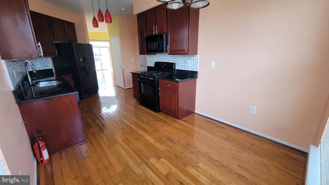 a kitchen with granite countertop a refrigerator stove and sink