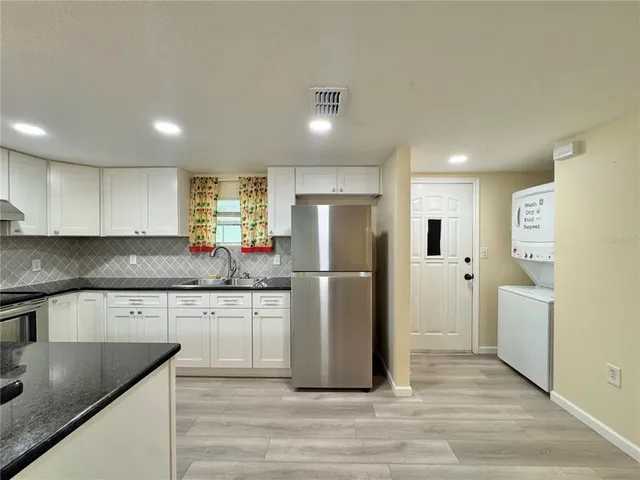 a kitchen with granite countertop white cabinets and white appliances