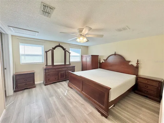 a bedroom with a large bed and a chandelier