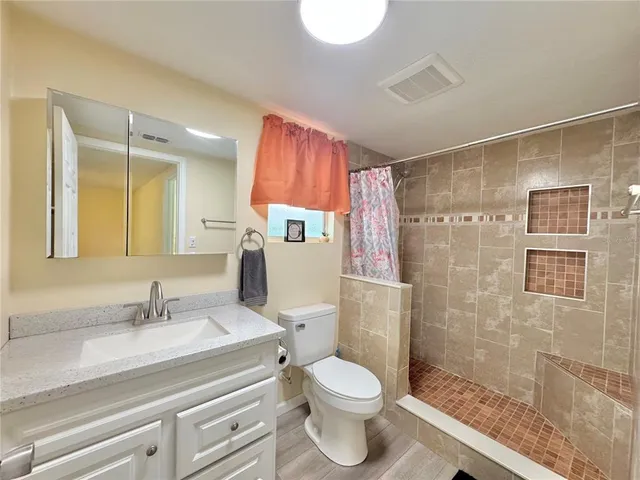 a bathroom with a sink toilet and shower