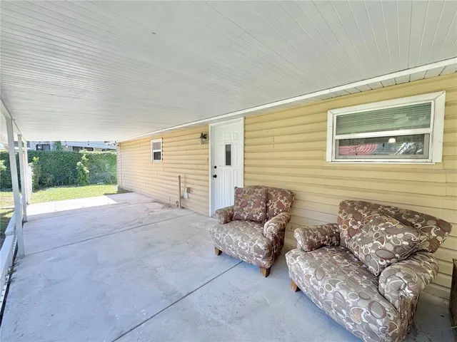 a view of a porch with furniture and garden