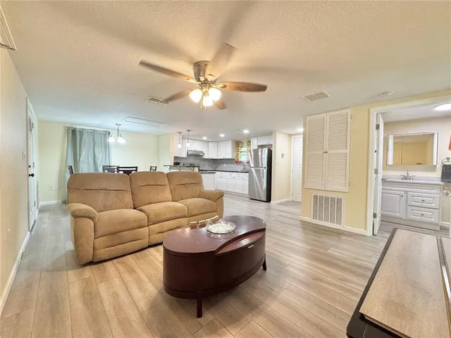 a living room with furniture and kitchen view